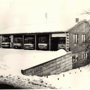 Bild in schwarz weiß mit Bussen in Garage im Winter mit Schnee